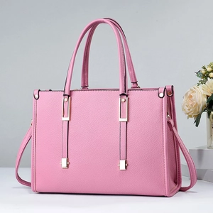 Detail of light pink tote bag featuring lychee texture and gold-tone hardware accents