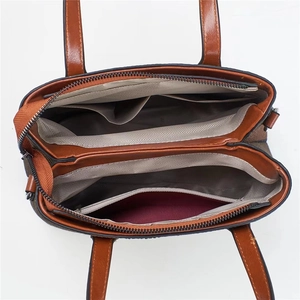 Brown cross-body shoulder bag featuring spacious multi-compartment interior layout
