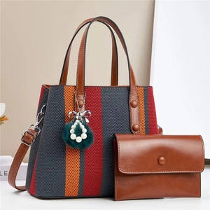 Detail of striped woven tote and matching wallet with faux fur pearl charm decoration