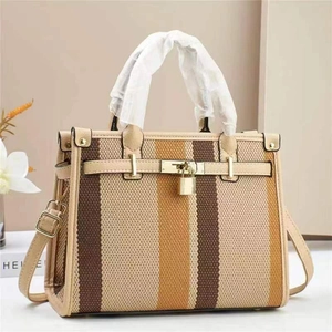 Detail of contrast striped tote bag with golden metal buckle and leather handles