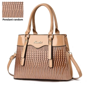 Detail view of khaki handbag featuring lizard texture contrast and metallic logo