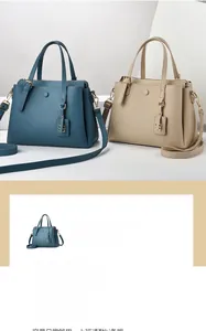 Close-up of lychee grain texture handbags in blue and beige with golden hardware