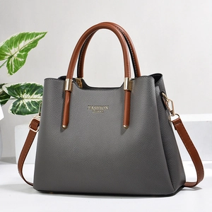 Detail view of large grey tote bag with brown handles and Fashion Queen text