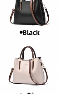 Detail view of large trapezoid handbags in black and beige with gold hardware accents
