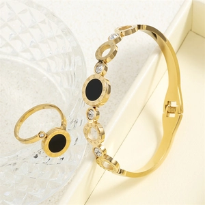 Detailed view of Roman numeral engraved gold bangle and ring set with black inlay