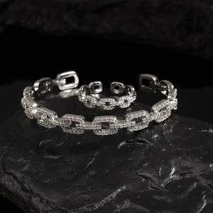 Detail of silver hollow geometric jewelry set with sparkling zircon micro-paving