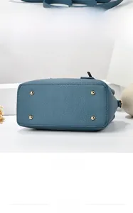 Detail view of the navy blue lychee leather handbag base with four protective gold studs