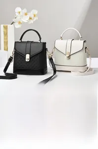 Detail of woven texture and metal lock on black and beige leather bucket bags