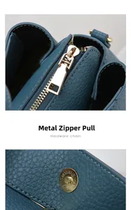 Detail of teal lychee leather texture and golden metal zipper with precision engraving