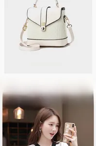 Detail view of white bucket bag with woven texture, metal clasp and crossbody strap