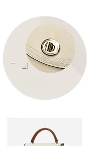 Close-up of golden rotating lock with floral hollow detail on cream bucket bag