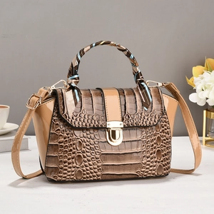 Detail van kaki crossbodytas met krokodillentextuur, zijden sjaalhandvat en gouden slot