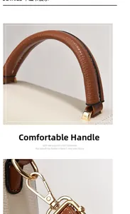 Detail of off-white lychee leather handbag showing brown top handle and gold metal hooks