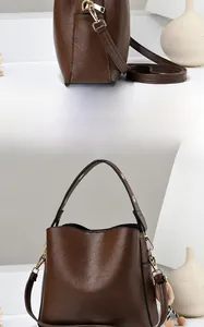 Detail view of a dark brown PU leather bucket bag with gold hardware and shoulder strap