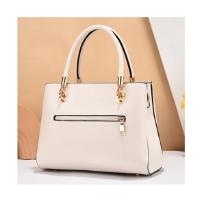 Detail view of beige leather bag with a gold zipper pocket and premium hardware