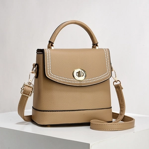 Minimalist apricot leather bucket bag with elegant pearl trim and metal clasp