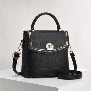 Structured black leather bucket bag with white stitching and gold turn-lock closure