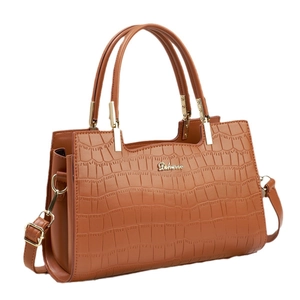 Brown crocodile textured tote bag with golden hardware and adjustable shoulder strap