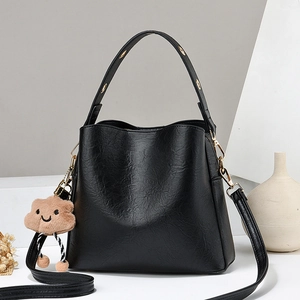 Minimalist black PU leather bucket bag with golden eyelets and brown cloud charm decoration