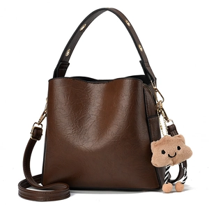 Minimalist dark brown bucket bag with wide handle and cute teddy bear charm