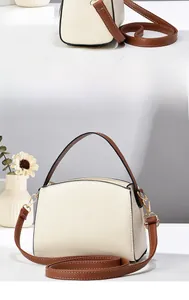 Vue latérale détaillée du sac à bandoulière beige avec anses brunes et boucles dorées