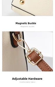 Détails d'un sac en cuir beige avec rivets dorés de protection et mousqueton amovible