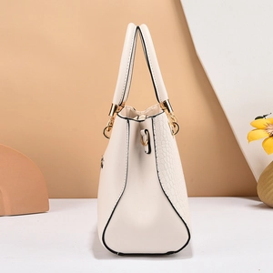 Elegant cream white handbag with crocodile texture and golden hardware from a side view