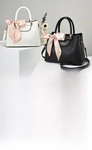 Detail of crocodile pattern tote bag with logo-print body and decorative handle scarf