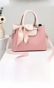 Pink crocodile-textured handbag with golden logo and decorative heart silk scarf
