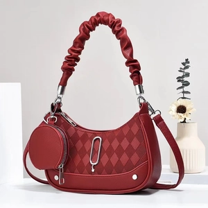 Detail of wine red quilted handbag with ruffled handle and detachable round coin purse