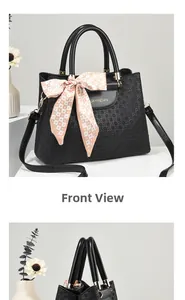 Detail of black woven texture handbag with decorative heart scarf and gold logo lettering