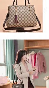 Détail du sac à main à damier avec breloque à pompon et bandoulière réglable