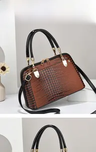 Detail of lizard pattern texture on brown leather handbag with gold zipper hardware