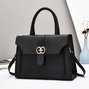 Vintage black crossbody bag with woven texture and gold ring buckle shown in a lifestyle set