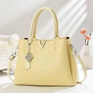 Pale yellow square-embossed leather tote bag with V-shaped metal buckle and long strap