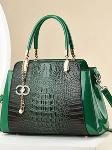 Deep green crocodile embossed tote bag with glossy finish and pearl pendant detail