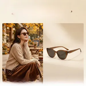 Dettaglio di occhiali da sole cat-eye ambra con montatura marrone su una modella donna