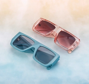 Detail of oversized square sunglasses in translucent pink and light blue with gradient lenses