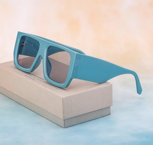 Side view of oversized blue square sunglasses featuring thick temples on a display box