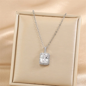 Close-up of elegant square halo pendant necklace with cubic zirconia on silk backdrop