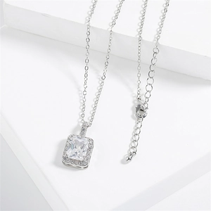 Elegant silver necklace featuring a rectangular zircon pendant on white minimalist podium