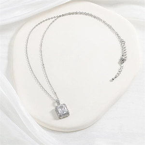 Detail shot of rectangular zircon pendant with halo setting on a silver chain necklace