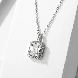 Detail of halo cubic zirconia pendant featuring a rectangular cut center stone in silver