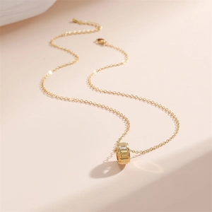 Détail macro du pendentif cylindre plaqué or 18K avec zircon et chaîne fine en O