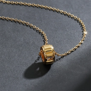 Collier minimaliste plaqué or avec pendentif en oxyde de zirconium sur fond texturé
