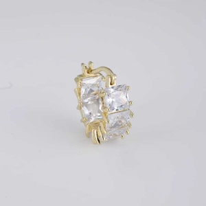 Detail of gold-plated huggie earrings with square-cut cubic zirconia and snap closure