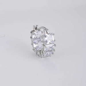 Macro shot of silver huggie earring featuring four square-cut clear cubic zirconia stones
