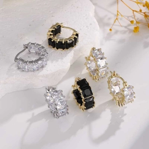 Detail of cubic zirconia hoop earrings set in gold and silver on stone tray