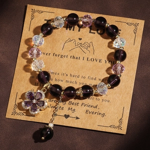 Detail of purple crystal beads and floral rhinestone pendant on a gold chain