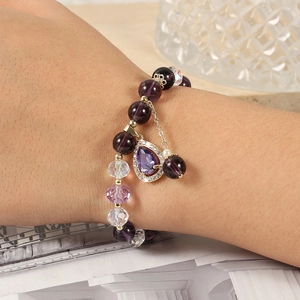 Detailed shot of purple crystal beaded bracelet with teardrop pendant on wrist